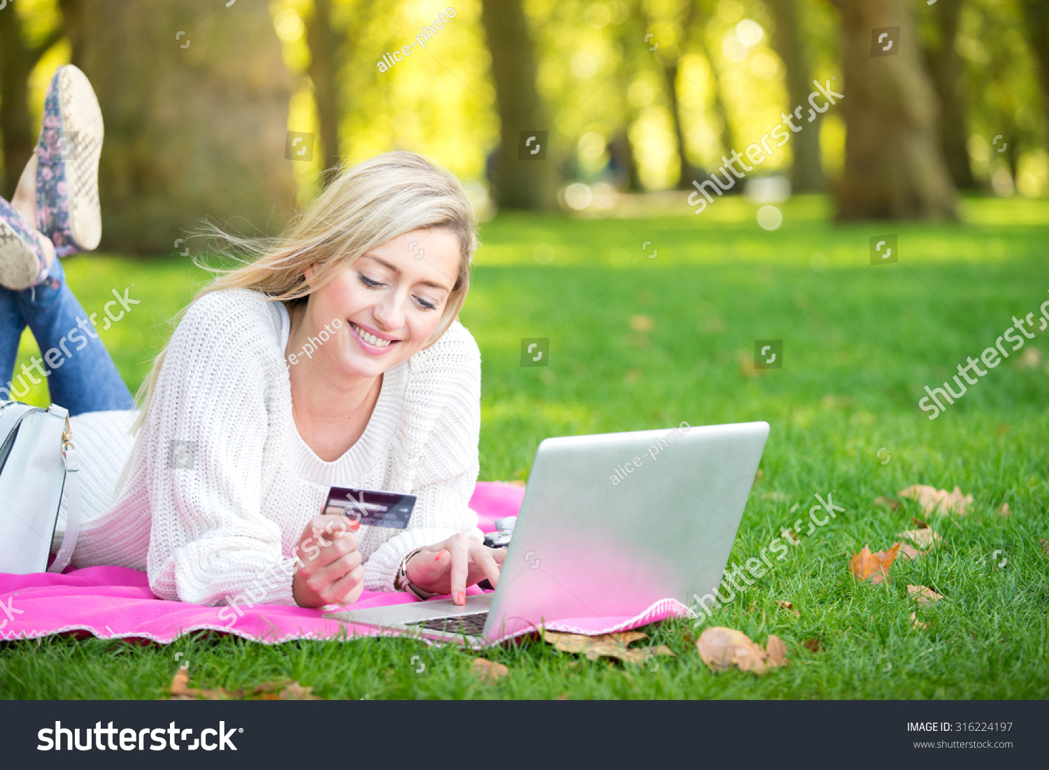 一个女人用信用卡网上购物与一台笔记本电脑在