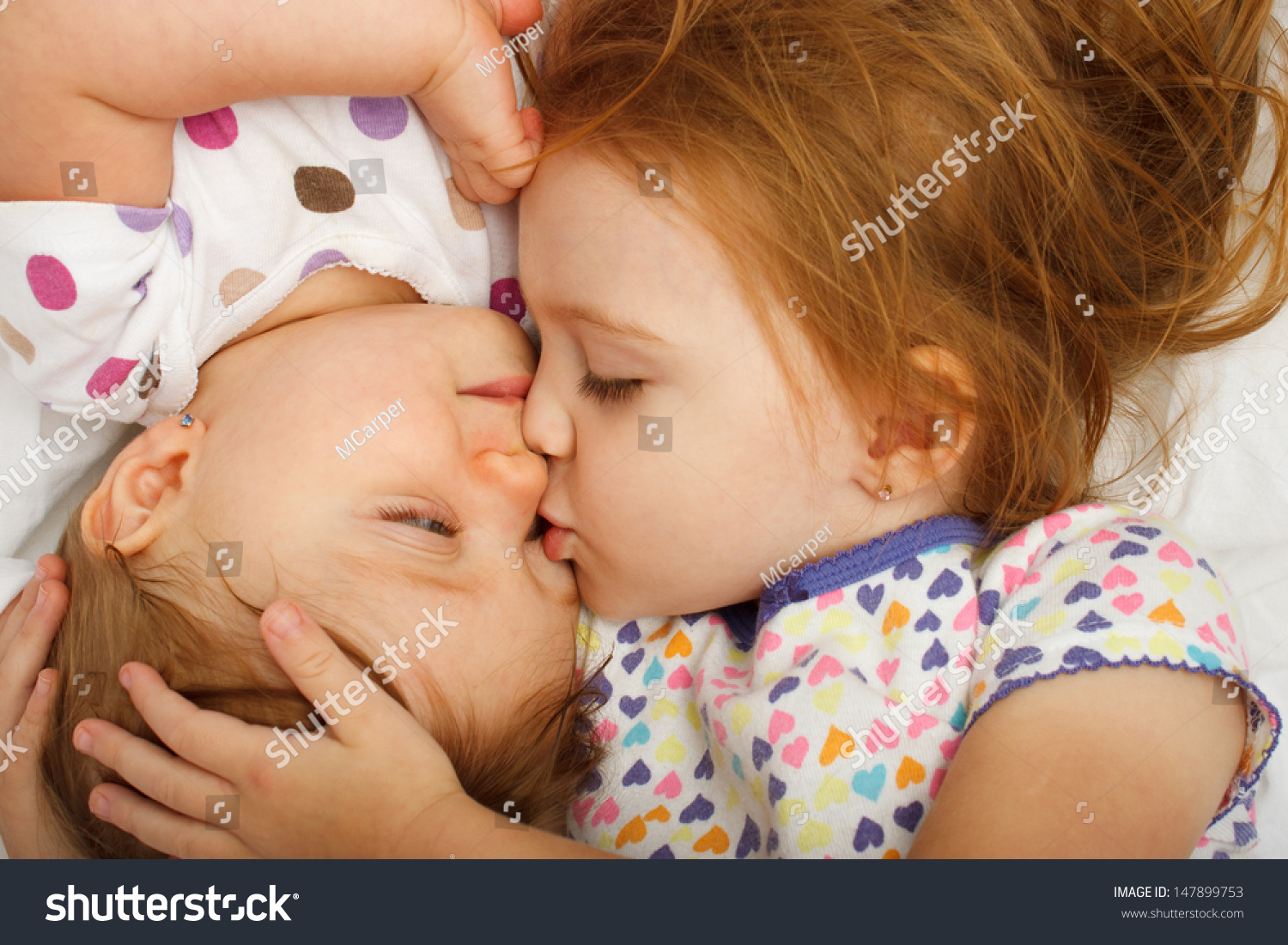 预览大图  姐姐在床上亲吻宝宝 原标题 older sister kissing bab 