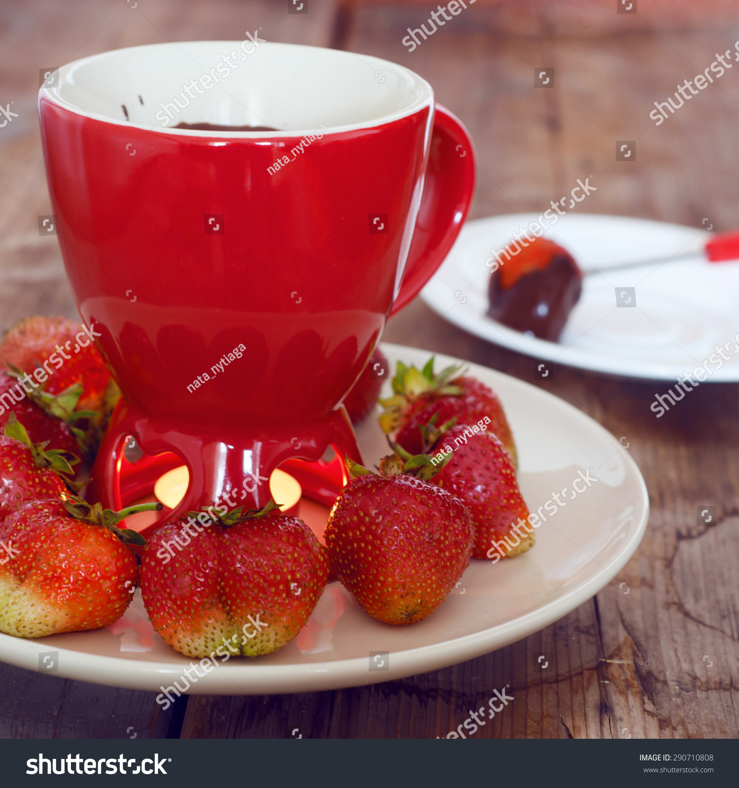 chocolate fondue with strawberries in a red fondue cup-食品及