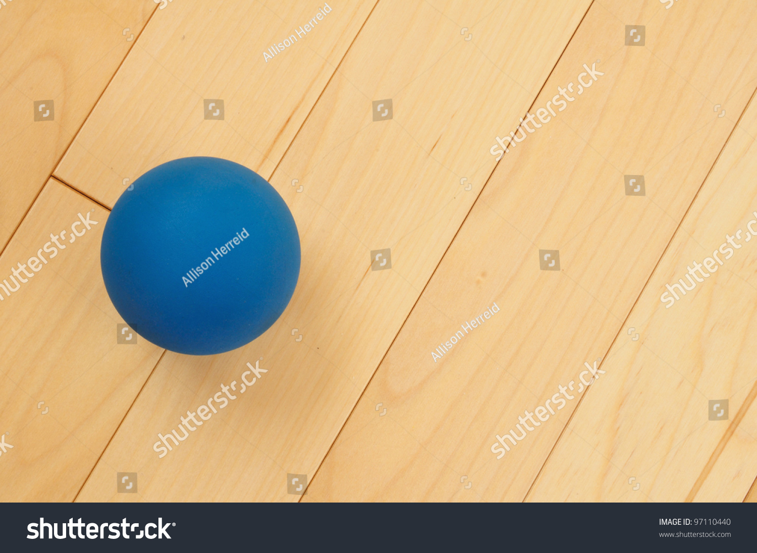 blue rubber racquetball on hardwood court floor